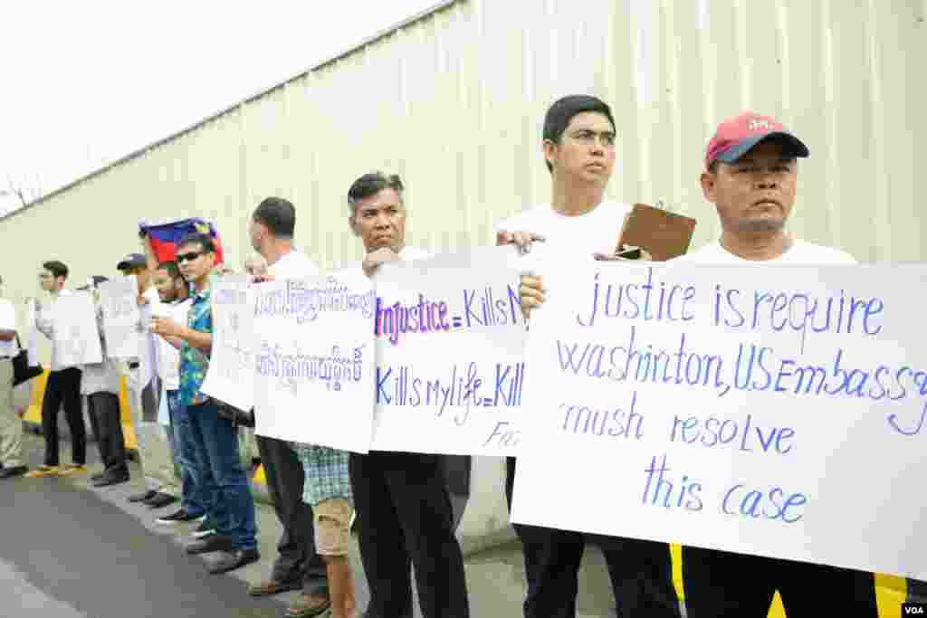 សន្តិសុខ​ដែល​ត្រូវ​បាន​ស្ថានទូត​សហរដ្ឋ​អាមេរិក​បញ្ឈប់​កាល​ពី​ប៉ុន្មាន​ខែ​មុន​​​និង​គ្រួសារ​របស់ពួកគេ​បាន​មក​ធ្វើ​បាតុកម្ម​តវ៉ា​រក​យុត្តិធម៌​ដោយ​អហិង្សា​នៅ​ខាង​មុខ​ស្ថានទូត​អាមេរិករាជធានី​ភ្នំពេញ​ ​កាល​ពីព្រឹក​ថ្ងៃទី​១៩ មិថុនា ឆ្នាំ ២០១៨។(ទុំ ម្លិះ/VOA)