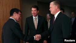 14일 도쿄를 방문한 스티븐 비건 미국 국무부 대북정책 특별대표(오른쪽)가 고노 다로 일본 외무상과 만나 악수하고 있다.
