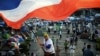 A Thai anti-government protester waves a national flag during ongoing rallies at a protest site at Victory Monument in downtown Bangkok, Jan. 24, 2014. 