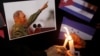 People place candles beside a picture of Fidel Castro, as part of a tribute, following the announcement of the death of the Cuban revolutionary leader, in Tegucigalpa, Honduras, Nov. 26, 2016.