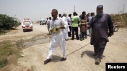 Pasukan keamanan Pakistan mengamankan lokasi serangan terhadap bisa penumpang di Karachi, Rabu (13/5).