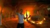 A protester reacts as the U.S. Consulate in Benghazi is seen in flames during a protest by an armed group said to have been protesting a film being produced in the United States September 11, 2012. 