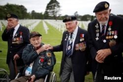 WWII D-Day veterans, including Richard Llewellyn and Mervyn Kersh from Britain and Norman Duncan from the U.S., attend a ceremony at Normandy American Cemetery and Memorial situated above Omaha Beach, France.