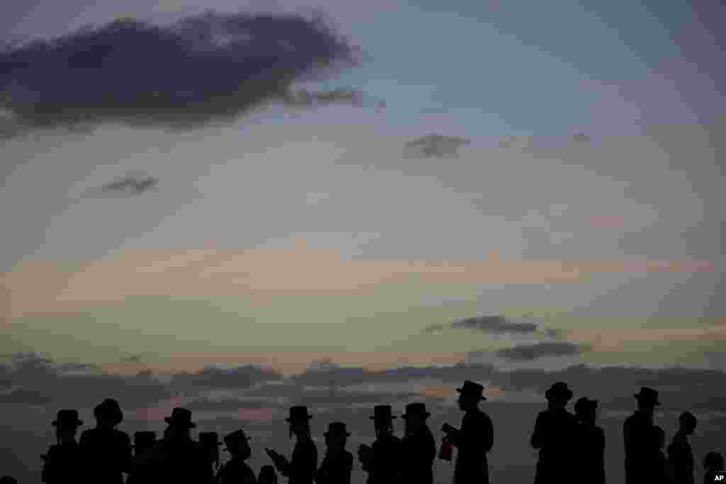 បុរស​កាន់​សាសនា​ជ្វីព​បែប Ultra-Orthodox នៃ​និកាយ Vizhnitz Hassidic នៅ​ជើង​ភ្នំ​ ដែល​អាច​មើល​ទៅ​សមុទ្រ​មេឌីទែរ៉ានេ ខណៈ​ដែល​ពួកគេ​ចូលរួម​នៅ​ក្នុង​ពិធី​បុណ្យ Tashlich ក្នុង​ក្រុង Herzeliya ប្រទេស​អ៊ីស្រាអែល។