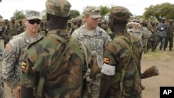 In this April 20, 2011 file photo, U.S. Army soldiers are seen with Uganda People's Defence Force soldiers at the closing ceremony for operation ATLAS DROP 11, an annual joint aerial delivery exercise, in Soroti, Uganda. While putting few U.S. 