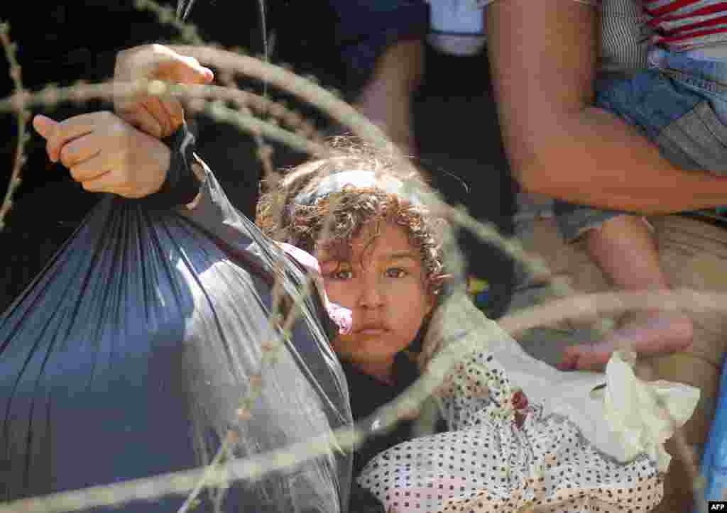Migrants wait for Macedonian police to allow them to cross at the border line between Greece and Macedonia near the town of Gevgelija.