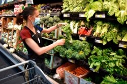 FILE - Crystal Dvorak shops at WinCo Foods, May, 7, 2021, in Billings, Mont. Dvorak was getting ingredients to make a soup with potatoes and onions she got from a food bank after recently losing her job as an audiologist.