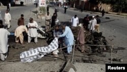 巴基斯坦奎达的警察和救援人员掩盖在爆炸中丧生者的尸体，2017年6月23日