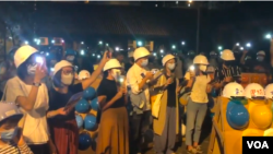 300多名蒙面的集会参加者在25号（星期五）晚上8点左右在九龙土瓜湾的牛棚艺术村空地上聚集，出席香港艺术家与当地社区合作举办的艺术展览开幕仪式。