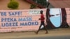 A young boy walks past a wall with graffiti urging people to wear face masks in Harare, May, 28, 2020. Manhunts have begun after hundreds of people fled quarantine centers in Zimbabwe and Malawi.