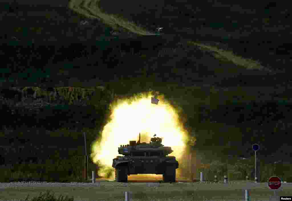 A T-72 tank, operated by a crew from Kazakhstan, fires at a target during the Tank Biathlon competition, part of the International Army Games 2016, at a range in the settlement of Alabino outside Moscow, Russia.