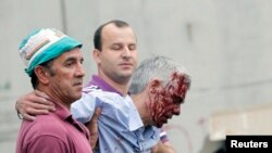 Train driver Francisco Jose Garzon (R) is helped by two men after his train crashed near Santiago de Compostela, northwestern Spain, July 24, 2013.