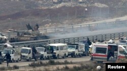 Les forces loyalistes syriennes de Bachar Al Assad encadrent un convoi de bus de civils qui fuient l'est d' Alep, Syrie le 16 décembre 2016. 