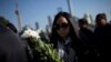 A woman offers flowers during a memorial ceremony in memory of people who were killed in a stampede incident during a New Year's celebration, on the Bund in Shanghai, Jan. 1, 2015. 