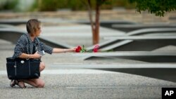 资料照：一名女子于9-11这一天在五角大楼纪念园献花。摄于2014年。