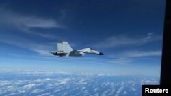 资料照片：美国印太司令部公布的视频显示中国海军一架歼-11战斗机2022年12月21日在南中国海的国际空域以不安全的方式拦截美国空军RC-135侦察机。