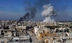 FILE - Smoke billows over the town of Saraqeb in the eastern part of the Idlib province in northwestern Syria, following bombardment by Syrian government forces, Feb. 27, 2020.