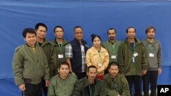 在泰国外交部提供的这张照片中，2023年11月24日星期五，10名被释放的泰国人质和一名军官(左四)在合影。（美联社）