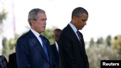 U.S. President Barack Obama and former President George W. Bush (R) attend a memorial for the victims of the 1998 U.S. Embassy bombing in Dar es Salaam, July 2, 2013.