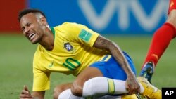 Le Brésilien Neymar se tient le tibia lors du match de quart de finale entre le Brésil et la Belgique lors de la Coupe du monde 2018 de football à Kazan Arena, Russie, 6 juillet 2018. 
