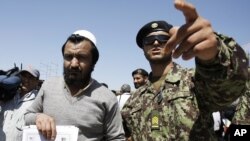 An Afghan soldier, right, escorts a released prisoner, Mohammad Karim, following a hand over ceremony of U.S.- run prison to Afghan government in Bagram north of Kabul, Afghanistan, Sept. 10, 2012. 