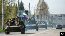 一队军车行驶在乌克兰东部城镇，领头的车上有俄罗斯国旗