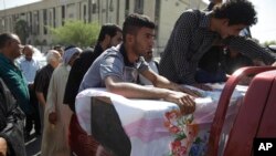 15일 이라크 바그다드에서 연쇄폭탄 공격으로 사망한 희생자의 시신을 가족들이 옮기고 있다.