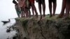 FILE - A group of Bangladeshi village children who have lost their homes due to erosion near the riverbed stand on the banks of the river Jamuna, in Manikgonj, 40 kilometers north of the Bangladesh capital of Dhaka, July 4, 2008. 