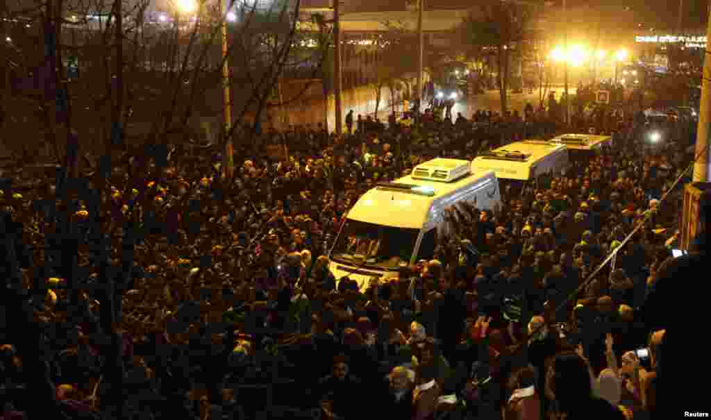 People accompany ambulances carrying the bodies of three Kurdish activists shot in Paris, in Diyarbakir, Turkey, January 16, 2013.