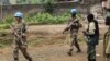 U.N. peacekeepers walk past rebel soldiers in Bunagana, July 7, 2012. 