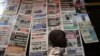 FILE - A boy walks past a newspaper kiosk at the Carrefour Wada district in Cameroon's capital Yaounde, Oct. 7, 2011. The country's National Communication Council has suspended dozens of media outlets and journalists for what is calls biased reporting.