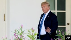 川普总统走向白宫西厢时向媒体挥手。（2018年7月18日）