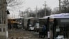 Buses wait along a road while travelling in the direction of the village of Debaltseve, Feb. 6, 2015.