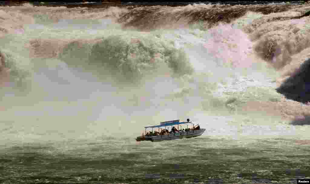 ទូក​ដឹក​ភ្ញៀវ​ទេសចរ​មួយ​ឆ្លងកាត់​ទឹក​ធ្លាក់ Rhine Falls ដែល​ជា​ទឹក​ធ្លាក់​ធំ​ជាង​គេ​ក្នុង​ទ្វីបអឺរ៉ុប​ក្នុង​ទីក្រុង​ Neuhausen​ ក្បែរ​ Schaffhausen​ ប្រទេស​ស្វីស។