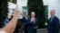 Vice President Mike Pence, center, with Treasury Secretary Steven Mnuchin, left, and White House national security adviser Robert O'Brien, waves as he turns to leave after speaking to reporters.