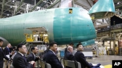 2015年9月23日，秦刚（前左一）随同中国国家主席习近平参观美国华盛顿州埃弗里特的波音工厂