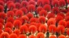 A girl laughs as she sits among hand fans during a mass performance at a children's martial arts fair in Foshan, Guangdong province, May 31, 2013. 
