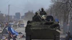 2022年3月19日，在乌俄冲突中，在被围困的乌克兰南部港口城市马里乌波尔，身穿无徽章制服的亲俄部队士兵驾驶着一辆装甲车。