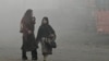Pedestrians walk along a road engulfed in thick smog in Lahore, Pakistan, Nov. 11, 2024.