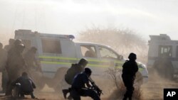 Policemen in teargas and dust open fire on striking miners at the Lonmin Platinum Mine near Rustenburg, South Africa, August 16, 2012. 