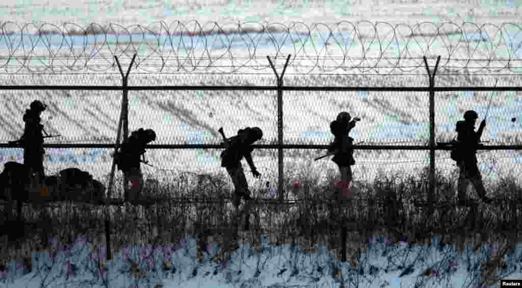 Tentara Korea Selatan memeriksa pagar militer saat berpatroli dekat zona demiliterisasi yang memisahkan Korea Utara dan Korea Selatan, di Paju, selatan Seoul (12/2).