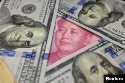 រូបឯកសារ៖ ក្រដា​សប្រាក់​ដុល្លារ​របស់សហរដ្ឋអាមេរិក និង​ប្រាក់​យ័ន​របស់​ចិន ត្រូវបាន​ថត​ជាមួយ​គ្នា កាលពីថ្ងៃទី២១ ខែមករា ឆ្នាំ២០១៦។