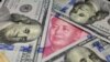 FILE: A U.S. 100 dollar bill featuring Benjamin Franklin is shown with a Chinese 100 yuan banknote with the late Chinese Chairman Mao Zedong, Jan. 21, 2016.