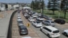 Residents queue up inside their cars for PCR tests at the St Vincent's Bondi Beach COVID-19 drive-through testing clinic on Dec. 22, 2021, in Sydney, as the number of COVID-19 cases keeps on the rise across the New South Wales state. (Photo by Mohammad FAROOQ / AFP)