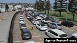 Residents queue up inside their cars for PCR tests at the St Vincent's Bondi Beach COVID-19 drive-through testing clinic on Dec. 22, 2021, in Sydney, as the number of COVID-19 cases keeps on the rise across the New South Wales state. (Photo by Mohammad FAROOQ / AFP)