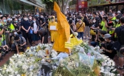 反送中运动首位牺牲性命的抗争者梁凌杰逝世一周年，网民在他堕下身亡的地点设置祭坛，挂上他死前穿着的黄色雨衣，供市民献花。 (美国之音/汤惠芸)