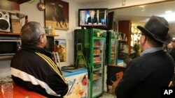 La gente ve al presidente francés Emmanuel Macron durante un discurso televisado a la nación, en Hendaya, suroeste de Francia, el lunes 10 de diciembre de 2018.