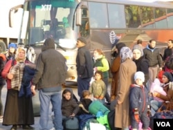 New arrivals are transferred by bus to other refugee camps in Athens. (Henry Ridgwell/VOA)