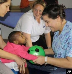 Zithulele physiotherapists Laura Grobicki (left) and Stephanie Benn (right) play with a young patient with cerebral palsy, as occupational therapist Shannon Morgan looks on. Compassion is the hospital’s mantra