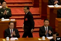 在人大会议开幕式上，中国总理李克强在中国主席习近平身边走过，上台做工作报告(2016年3月5日 )